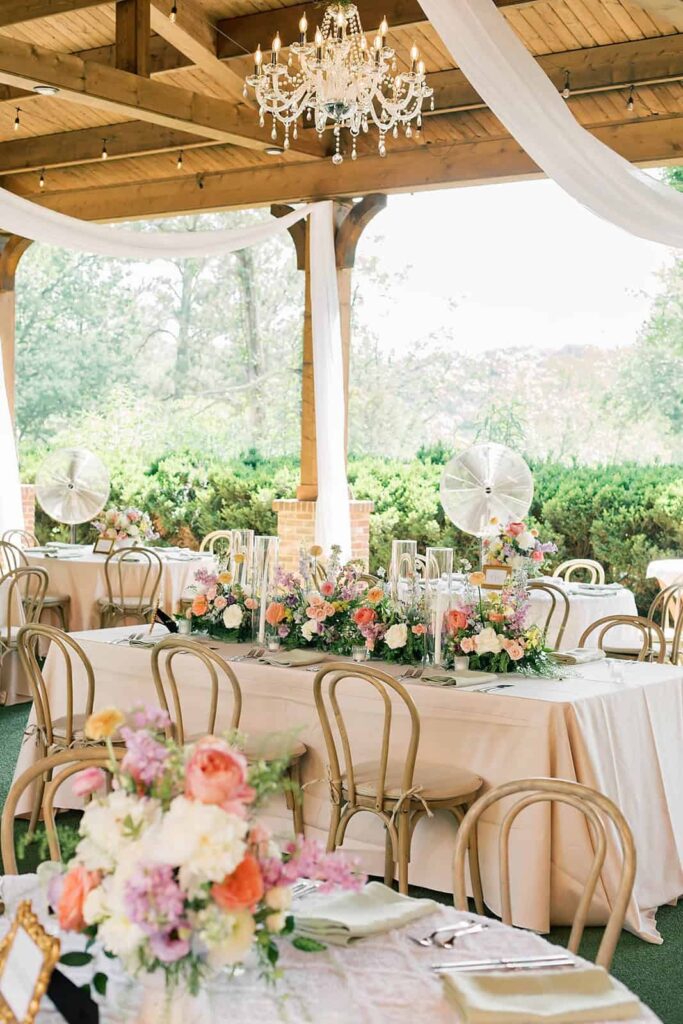 Reception tables at Barnsley Resort ruins with spring color palette table arrangements and drapery